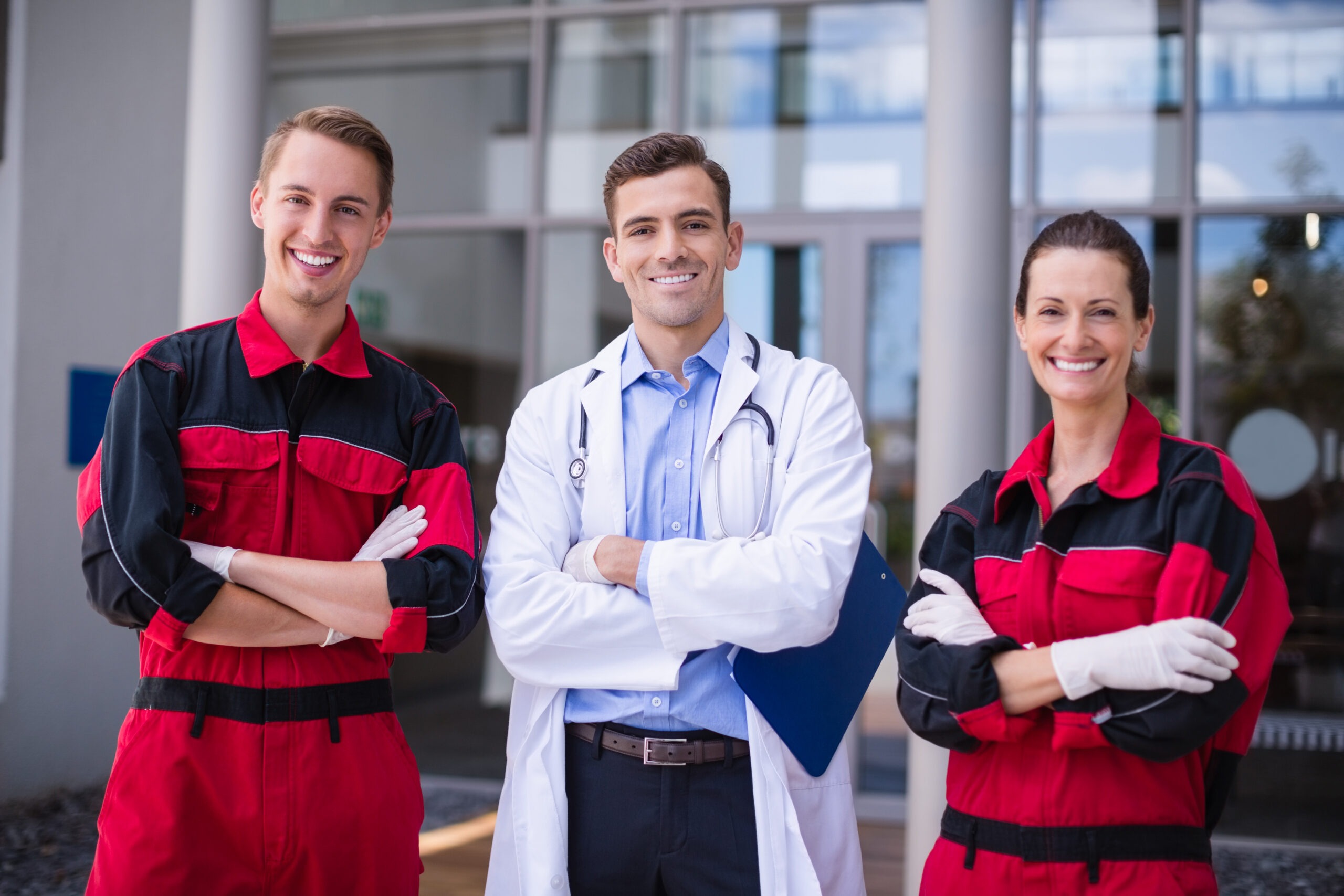 Portrait of doctor and paramedic standing with arms crossed at hospital
