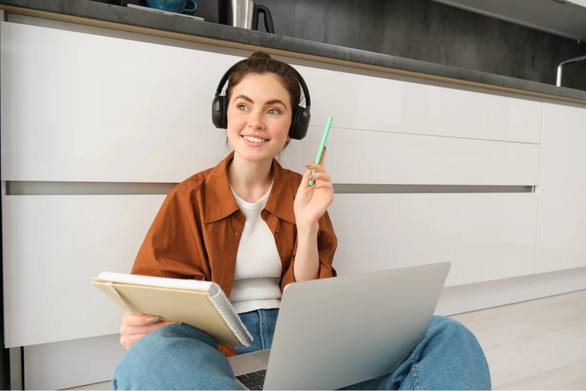 enthusiastic-young-woman-found-solution-looks-happy-sits-floor-does-homework-laptop 1